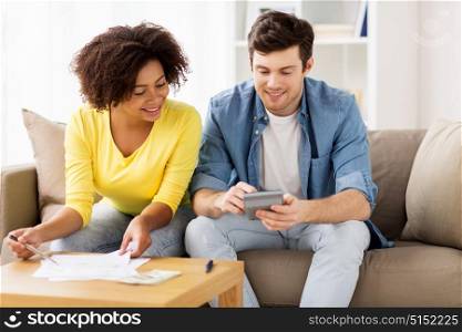 family budget, savings and people concept - happy couple with papers and calculator at home. happy couple with papers and calculator at home