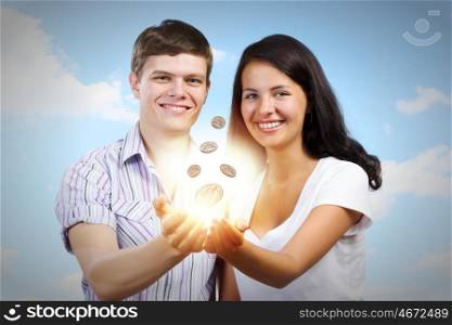 Family budget. Young happy couple holding cent in palms