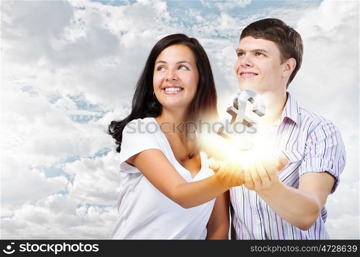 Family budget. Young happy couple holding pound sign in palms