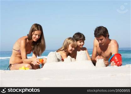 Family Building Sandcastles On Beach Holiday