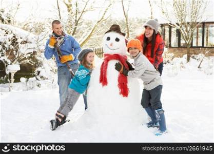 Family Building Snowman In Garden