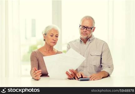 family, business, savings, age and people concept - senior couple with papers and calculator at home
