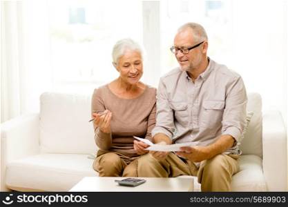 family, business, savings, age and people concept - smiling senior couple with papers and calculator at home