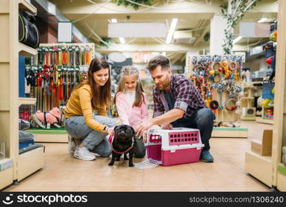 Family buying supplies for little puppy in petshop. Father, mother and dauther chooses accessories for dog in pet shop. Family buying supplies for little puppy in petshop