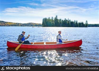 Family canoeing on sunny Lake of Two Rivers, Ontario, Canada