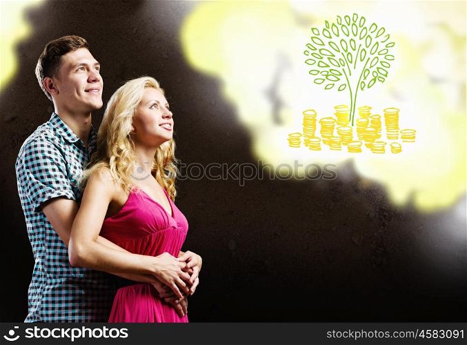 Family capital. Young happy couple dreaming about family wealth