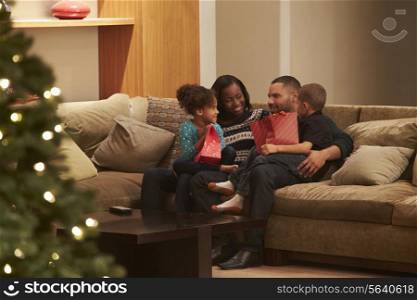 Family Celebrating Christmas At Home Viewed From Outside