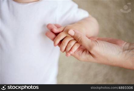 family, charity and people concept - close up of little baby and mother hands