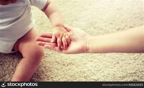 family, charity and people concept - close up of little baby and mother hands. close up of little baby and mother hands