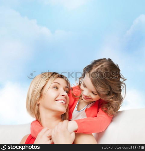 family, child and happiness concept - hugging mother and daughter