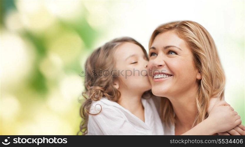 family, child and happiness concept - hugging mother and daughter