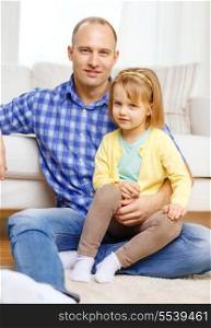 family, child and happiness concept - smiling father and daughter sitting on the floor at home