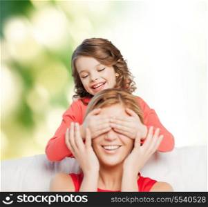 family, child and happiness concept - smiling mother and daughter making a joke
