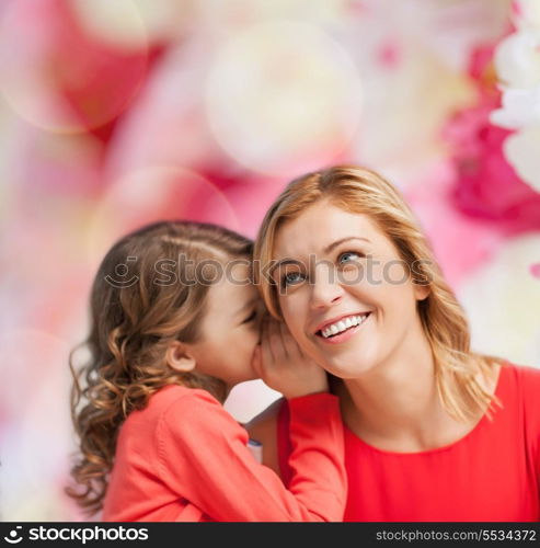 family, child and happiness concept - smiling mother and daughter whispering gossip