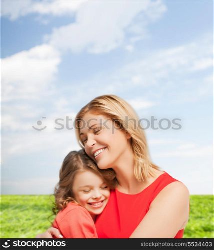 family, child and happiness concpt - hugging mother and daughter