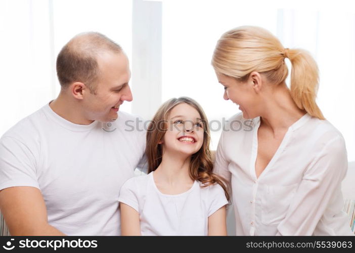 family, child and home concept - smiling parents and little girl at home
