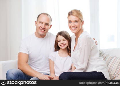 family, child and home concept - smiling parents and little girl at home