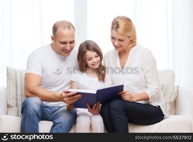 family, child and home concept - smiling parents and little girl with book at home