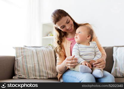 family, child and motherhood concept - happy smiling young mother with little baby at home. happy young mother with little baby at home