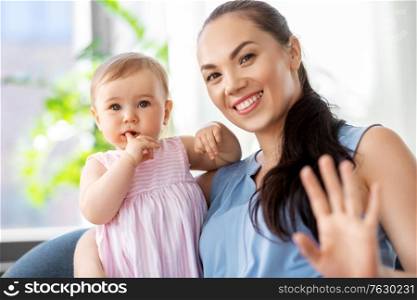 family, child and motherhood concept - portrait of happy smiling mother with little baby daughter at home. happy mother with little baby daughter at home