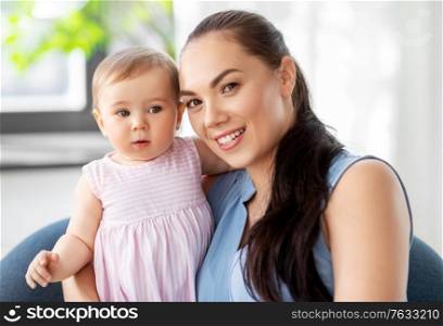 family, child and motherhood concept - portrait of happy smiling mother with little baby daughter at home. happy mother with little baby daughter at home
