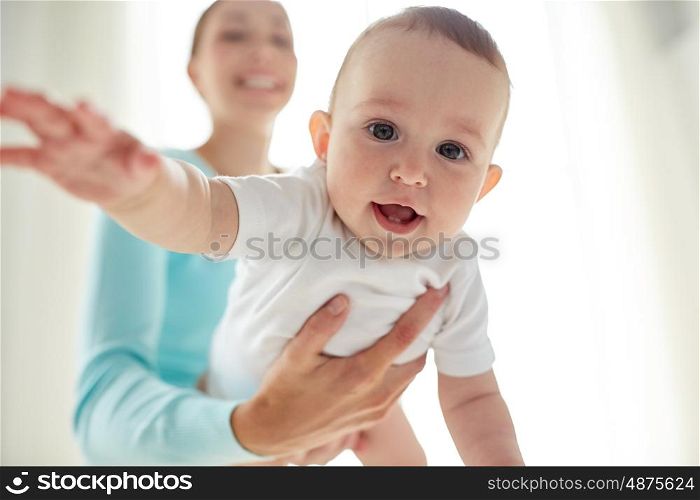 family, child and parenthood concept - close up of happy smiling young mother with little baby at home
