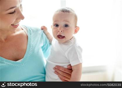 family, child and parenthood concept - close up of happy smiling young mother with little baby at home. happy young mother with little baby at home