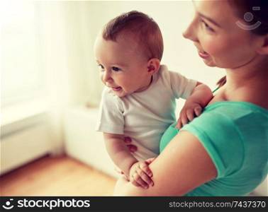 family, child and parenthood concept - close up of happy smiling young mother with little baby at home. happy young mother with little baby at home