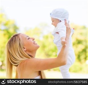 family, child and parenthood concept - happy mother holding little baby in park