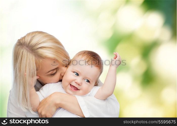 family, child and parenthood concept - happy mother kissing smiling baby