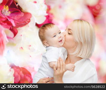 family, child and parenthood concept - happy mother kissing smiling baby