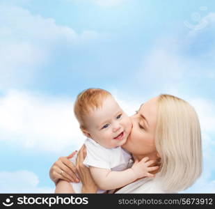 family, child and parenthood concept - happy mother kissing smiling baby