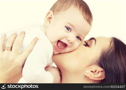 family, child and parenthood concept - happy mother kissing smiling baby