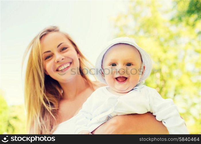 family, child and parenthood concept - happy mother with little baby in park