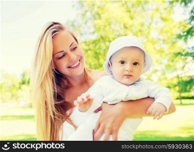 family, child and parenthood concept - happy mother with little baby in park