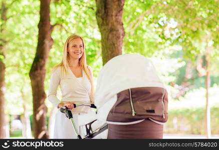 family, child and parenthood concept - happy mother with stroller in park