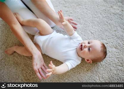 family, child and parenthood concept - happy smiling young mother playing with little baby at home