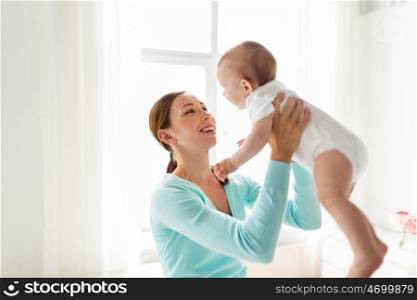 family, child and parenthood concept - happy smiling young mother with little baby at home