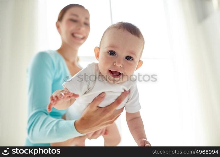 family, child and parenthood concept - happy smiling young mother with little baby at home. happy young mother with little baby at home