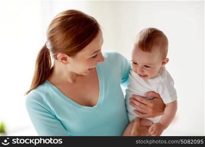 family, child and parenthood concept - happy smiling young mother with little baby at home. happy young mother with little baby at home