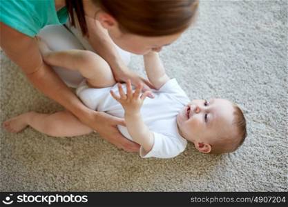 family, child and parenthood concept - happy young mother playing with little baby at home. happy mother playing with baby at home
