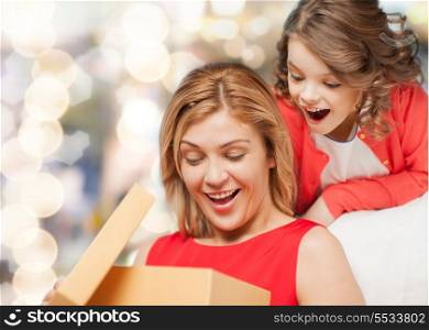 family, child, holiday and party - smiling mother and daughter with gift box