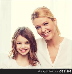 family, child, technology and home concept - smiling mother and little girl with laptop at home