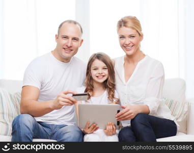 family, child, technology, money and home concept - smiling parents and little girl with tablet pc and credit card at home