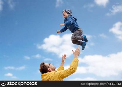 family, childhood and fatherhood concept - happy father and little son playing and having fun outdoors over blue sky and clouds background. father with son playing and having fun outdoors