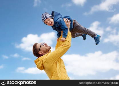 family, childhood and fatherhood concept - happy father and little son playing and having fun outdoors over blue sky and clouds background. father with son playing and having fun outdoors. father with son playing and having fun outdoors