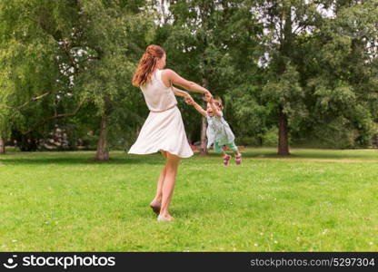 family, childhood and parenthood concept - happy mother with little baby girl playing and having fun at summer park. happy mother playing with baby girl at summer park