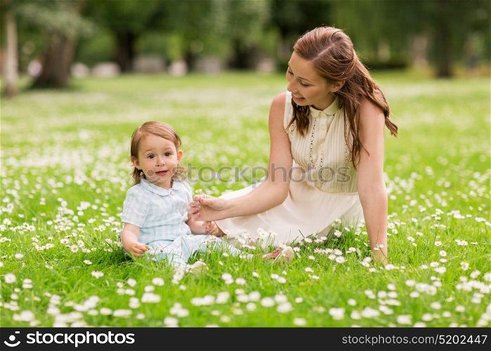 family, childhood and parenthood concept - happy mother with little baby girl at summer park. happy mother with baby girl at summer park