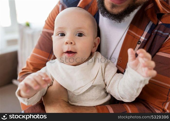 family, childhood, babyhood and people concept - close up of happy little baby boy with father at home. close up of happy little baby boy with father