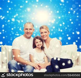 family, childhood, christmas holidays and people concept - smiling mother, father and little girl over blue snowy background